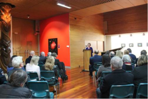 Pam on stage giving a presentation and thanking various people for their support.